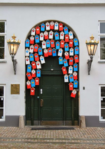 Украшение двери в одном из домов Копенгагена - над дверью повесили множество ярких скворечников